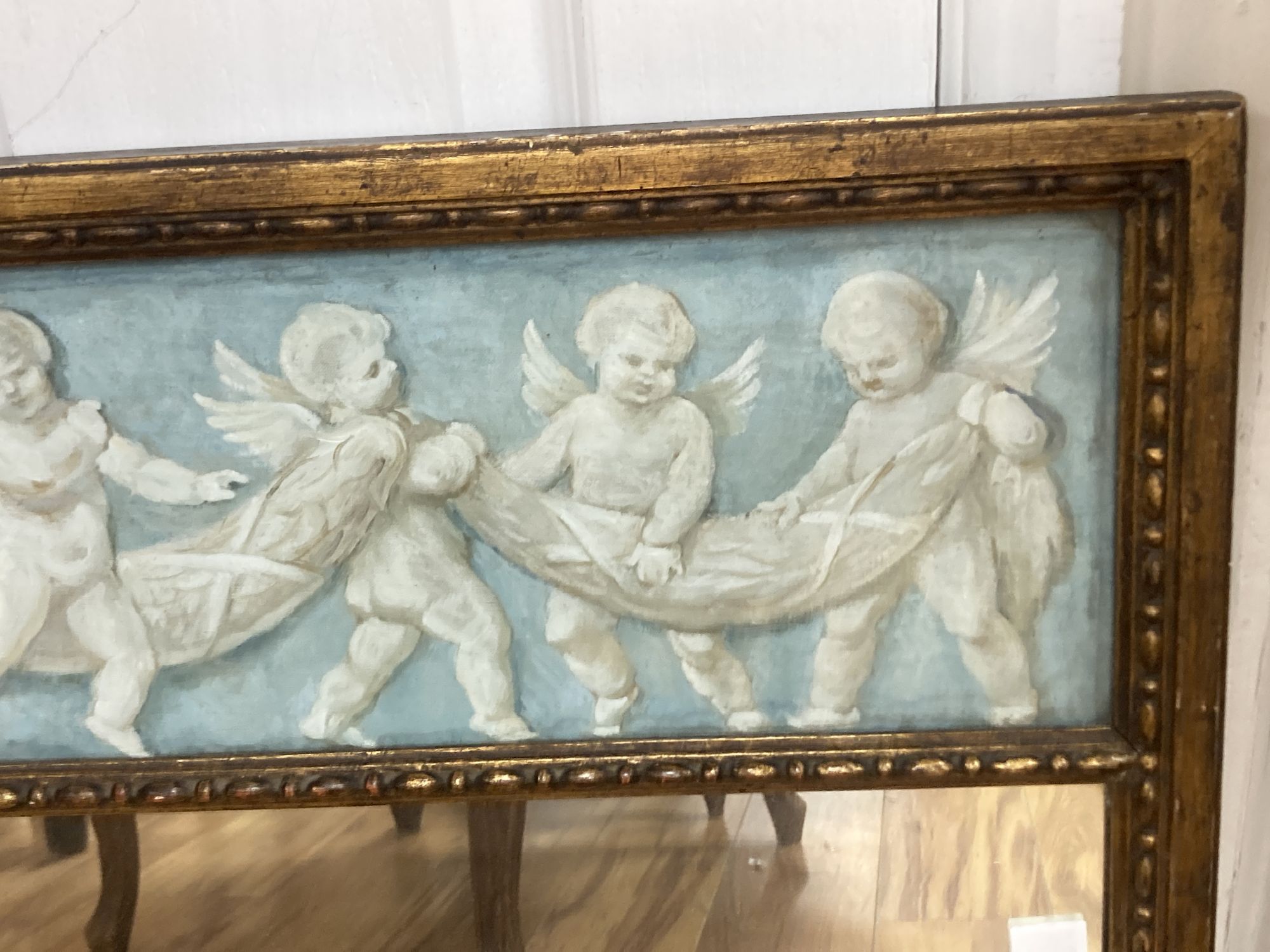 A wall mirror with painted cherub panel, width 78cm, height 62cm